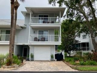 2015 Vista Del Sol Unit 108, Lutz, FL 33558 - raised beach house featuring a balcony, driveway, and a garage