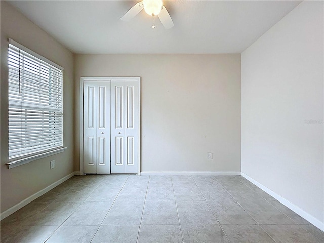 10347 Heron Hideaway Loop, Land O Lakes, FL 34638 - unfurnished bedroom featuring a closet, baseboards, light tile patterned flooring, and a ceiling fan