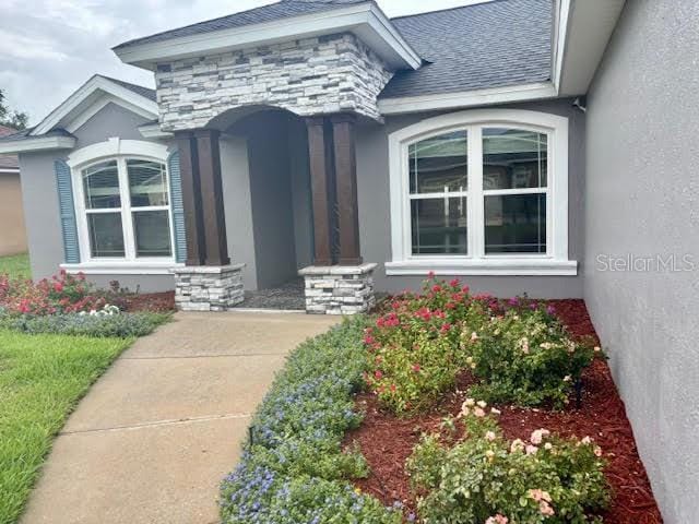 7144 Remington Oaks Loop, Lakeland, FL 33810 - property entrance featuring stucco siding and stone siding