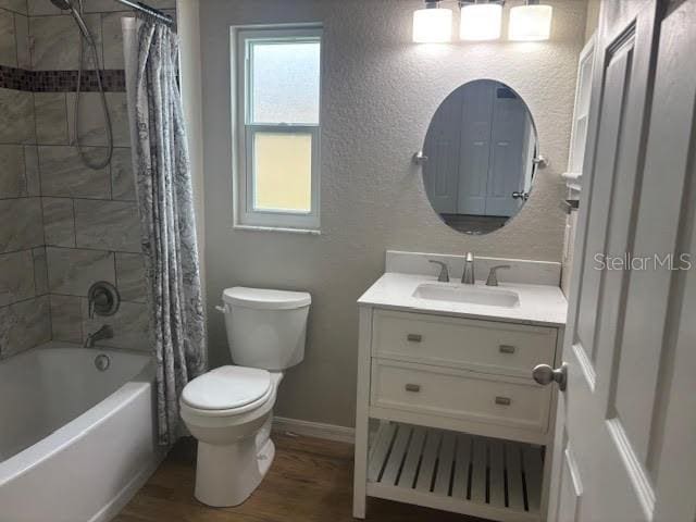 7144 Remington Oaks Loop, Lakeland, FL 33810 - full bath with toilet, vanity, wood finished floors, shower / tub combo with curtain, and baseboards