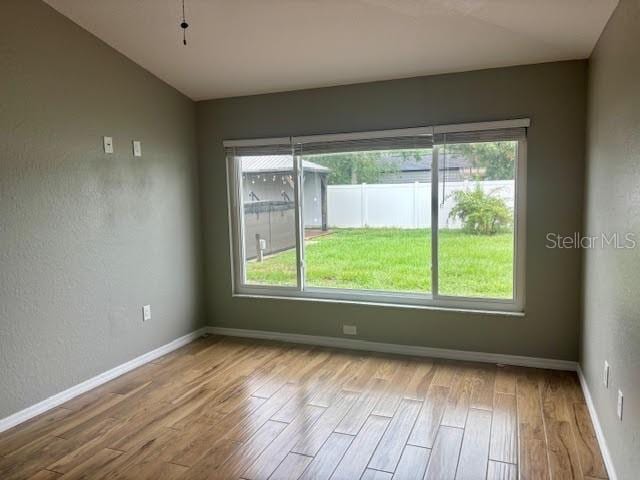 7144 Remington Oaks Loop, Lakeland, FL 33810 - unfurnished room featuring wood finished floors, healthy amount of natural light, and baseboards