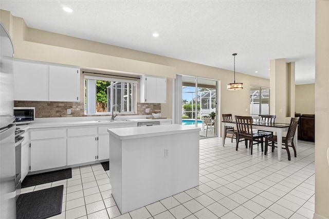 18219 Bittern Ave, Lutz, FL 33558 - kitchen with tasteful backsplash, light countertops, recessed lighting, white cabinetry, and a center island