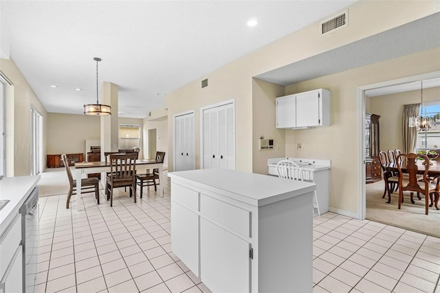 18219 Bittern Ave, Lutz, FL 33558 - kitchen with a center island, light tile patterned floors, light countertops, light carpet, and a chandelier