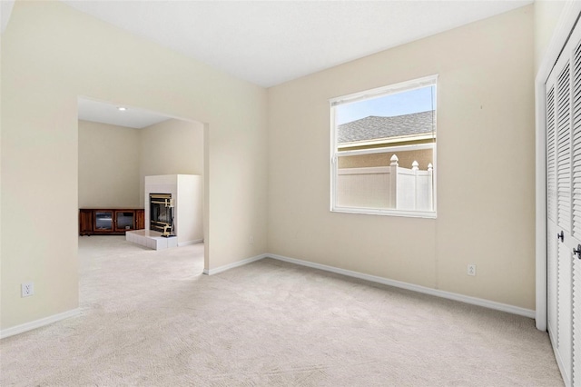 18219 Bittern Ave, Lutz, FL 33558 - carpeted empty room featuring a tiled fireplace and baseboards