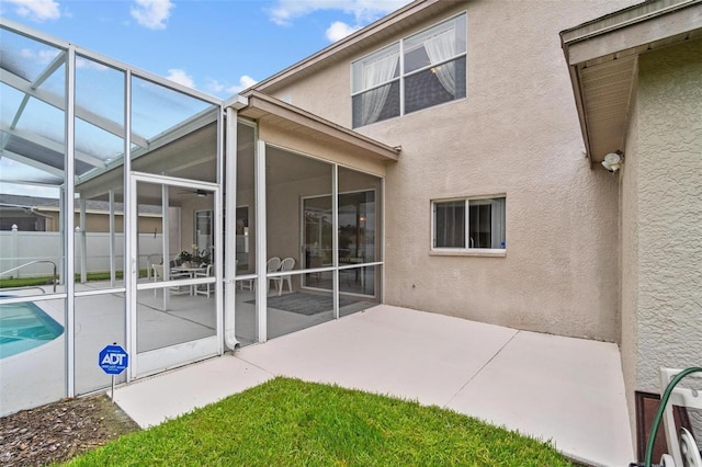 18219 Bittern Ave, Lutz, FL 33558 - back of property with stucco siding, a patio, and glass enclosure