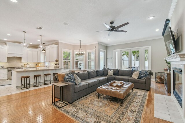 2522 W Watrous Ave, Tampa, FL 33629 - living room featuring a ceiling fan, healthy amount of natural light, a fireplace with flush hearth, light wood-type flooring, and recessed lighting