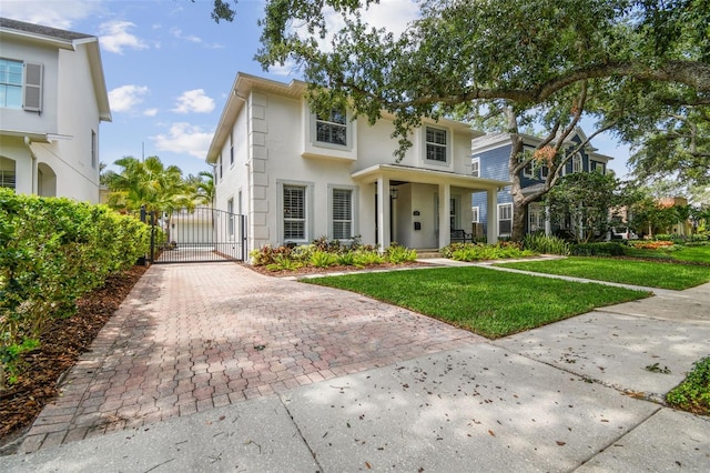 2522 W Watrous Ave, Tampa, FL 33629 - view of front of home with a gate, a front yard, stucco siding, and driveway