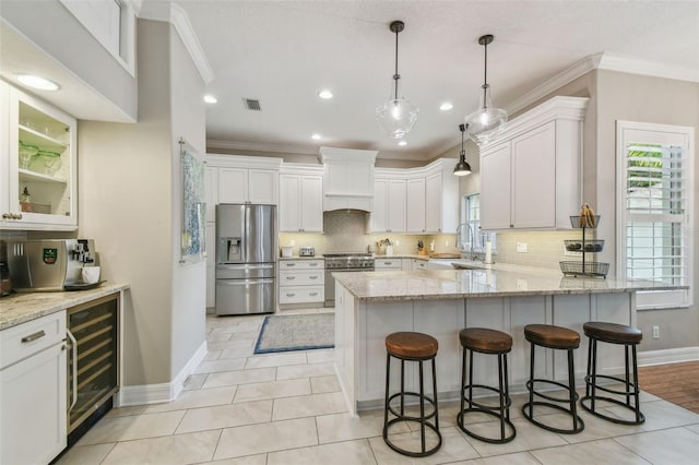 2522 W Watrous Ave, Tampa, FL 33629 - kitchen with stainless steel appliances, beverage cooler, decorative backsplash, a peninsula, and crown molding