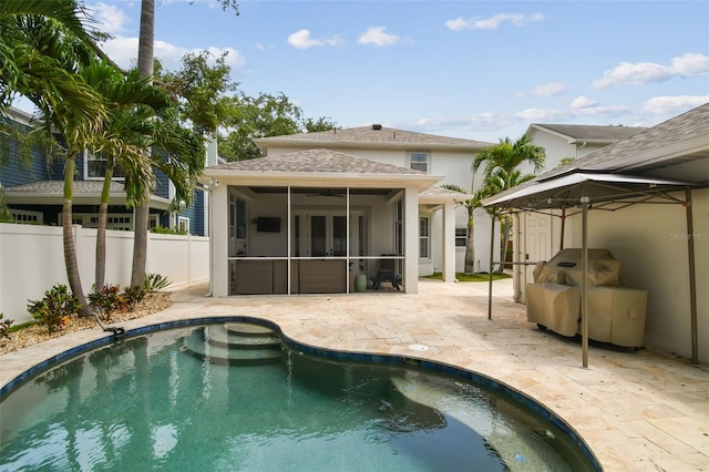 2522 W Watrous Ave, Tampa, FL 33629 - back of house featuring a sunroom, a fenced backyard, a patio, an outdoor pool, and stucco siding