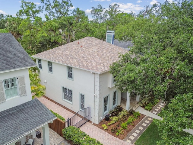 2522 W Watrous Ave, Tampa, FL 33629 - view of side of home with a shingled roof, stucco siding, and a gate