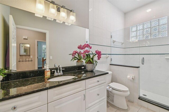 2522 W Watrous Ave, Tampa, FL 33629 - full bathroom featuring a shower stall, toilet, vanity, tile patterned flooring, and tile walls
