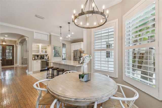 2522 W Watrous Ave, Tampa, FL 33629 - dining space featuring arched walkways, wine cooler, crown molding, a chandelier, and baseboards