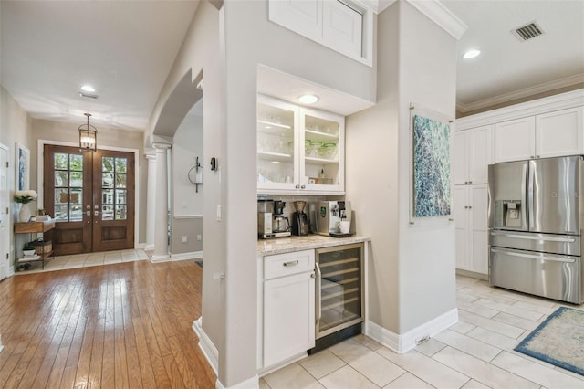 2522 W Watrous Ave, Tampa, FL 33629 - indoor dry bar featuring stainless steel fridge, wine cooler, ornate columns, arched walkways, and baseboards