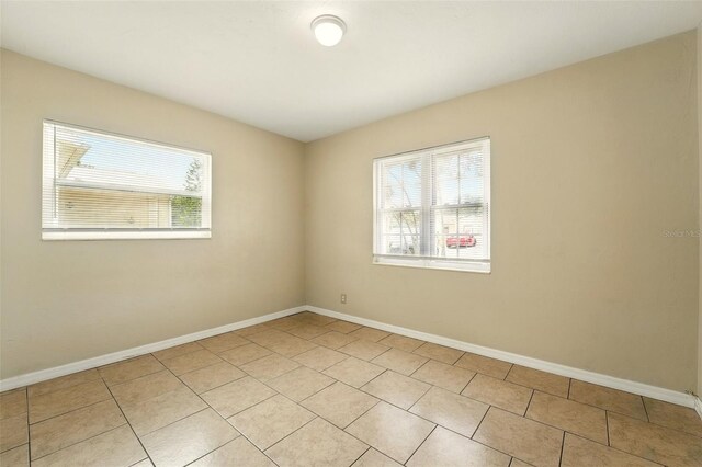 6941 58th Way N, Pinellas Park, FL 33781 - empty room featuring light tile patterned floors and baseboards