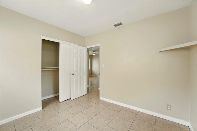 6941 58th Way N, Pinellas Park, FL 33781 - unfurnished bedroom with light tile patterned flooring, a closet, and baseboards