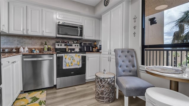 2616 Cove Cay Dr Unit 505, Clearwater, FL 33760 - kitchen featuring appliances with stainless steel finishes, backsplash, white cabinetry, and light wood-style flooring