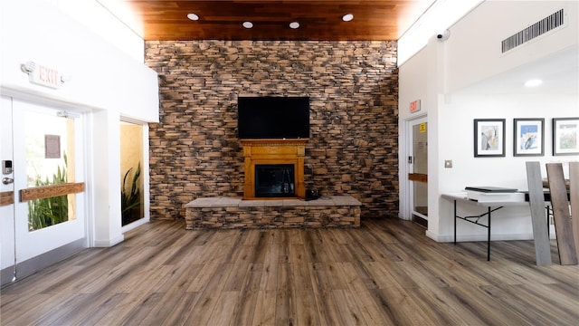 2616 Cove Cay Dr Unit 505, Clearwater, FL 33760 - unfurnished living room featuring wood finished floors, a fireplace with raised hearth, a high ceiling, and recessed lighting