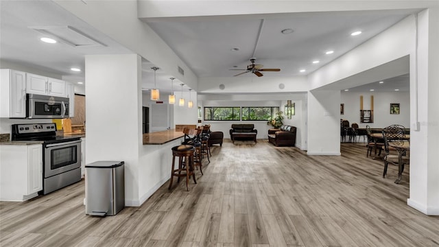 2616 Cove Cay Dr Unit 505, Clearwater, FL 33760 - kitchen featuring stainless steel appliances, light wood-style flooring, open floor plan, white cabinetry, and recessed lighting