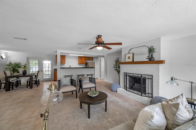 5053 18th St, Zephyrhills, FL 33542 - living area featuring a textured ceiling, ceiling fan, a fireplace, and light tile patterned flooring