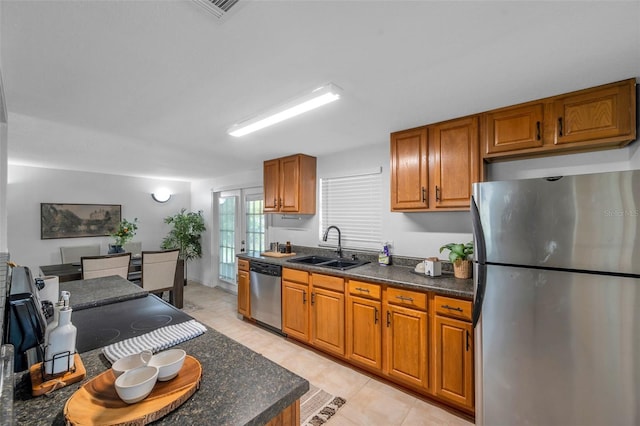 5053 18th St, Zephyrhills, FL 33542 - kitchen featuring stainless steel appliances, a sink, brown cabinetry, and light tile patterned floors
