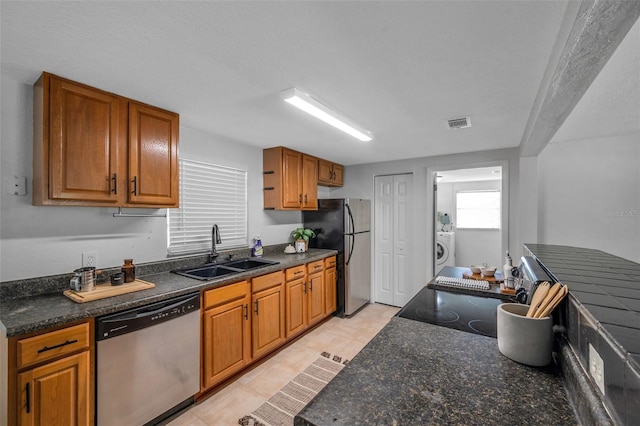 5053 18th St, Zephyrhills, FL 33542 - kitchen featuring stainless steel appliances, a sink, washer / clothes dryer, and brown cabinetry