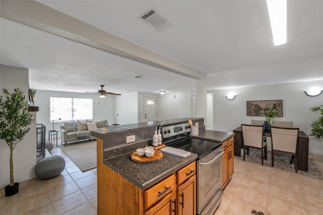 5053 18th St, Zephyrhills, FL 33542 - kitchen with electric range, brown cabinets, open floor plan, a kitchen island, and light tile patterned flooring