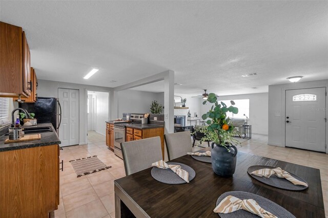 5053 18th St, Zephyrhills, FL 33542 - dining room with light tile patterned flooring, ceiling fan, a fireplace, and a textured ceiling