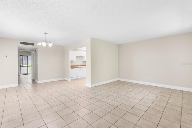 11805 Raintree Lake Ln Unit A, Tampa, FL 33617 - unfurnished living room with a chandelier, a sink, baseboards, a textured ceiling, and light tile patterned floors