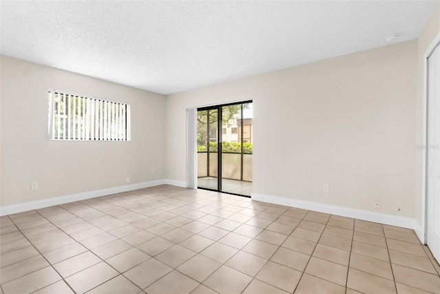 11805 Raintree Lake Ln Unit A, Tampa, FL 33617 - spare room with a textured ceiling, baseboards, light tile patterned floors, and a smoke detector