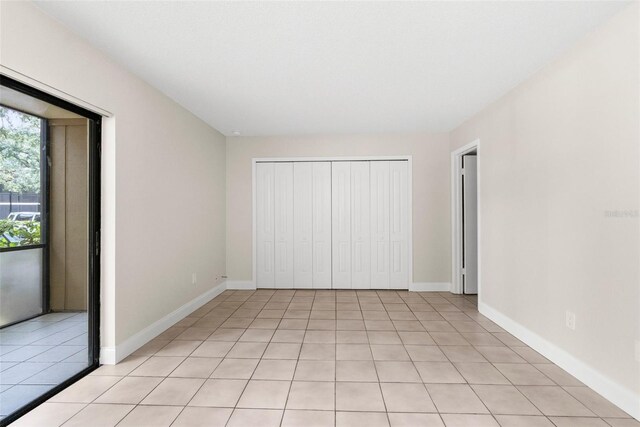 11805 Raintree Lake Ln Unit A, Tampa, FL 33617 - unfurnished bedroom with light tile patterned flooring, baseboards, and a closet