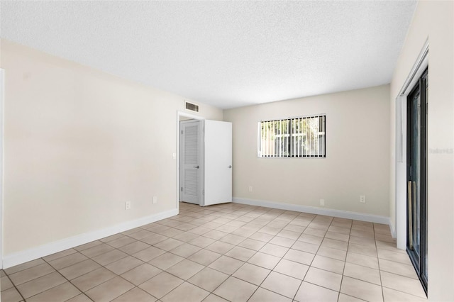 11805 Raintree Lake Ln Unit A, Tampa, FL 33617 - spare room with a textured ceiling, light tile patterned flooring, and baseboards