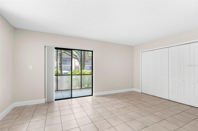 11805 Raintree Lake Ln Unit A, Tampa, FL 33617 - unfurnished bedroom with access to outside, light tile patterned floors, baseboards, and a closet