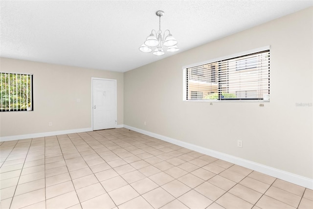 11805 Raintree Lake Ln Unit A, Tampa, FL 33617 - empty room with a chandelier, healthy amount of natural light, baseboards, and a textured ceiling