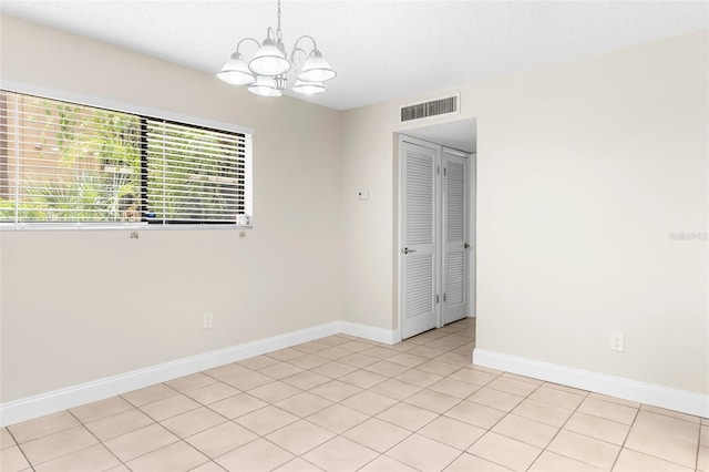11805 Raintree Lake Ln Unit A, Tampa, FL 33617 - empty room featuring a chandelier, baseboards, and light tile patterned flooring