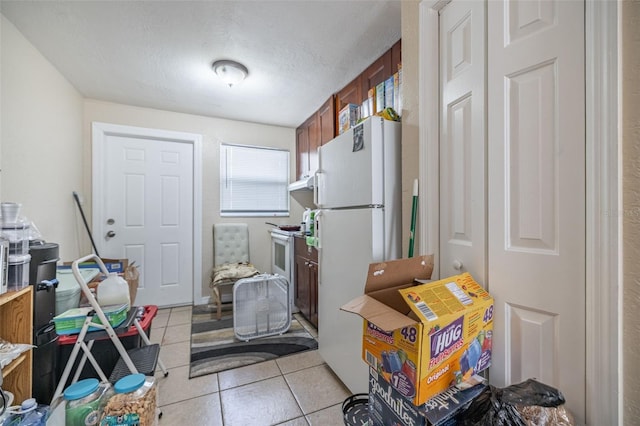 1799 Russell St S, Saint Petersburg, FL 33712 - kitchen with white appliances, light tile patterned floors, brown cabinets, and under cabinet range hood