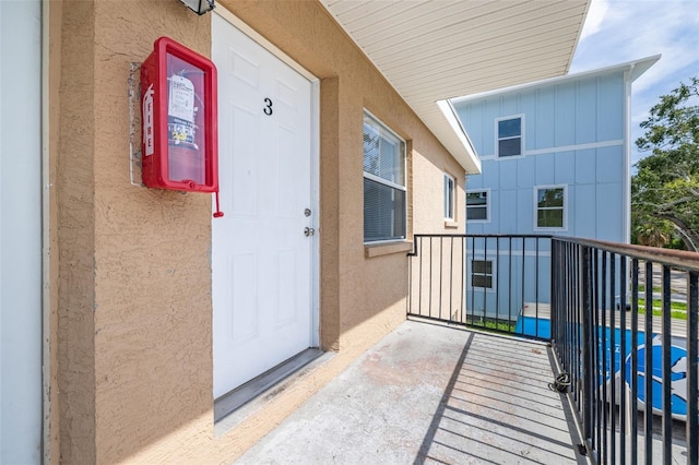 1799 Russell St S, Saint Petersburg, FL 33712 - doorway to property featuring stucco siding, a balcony, and board and batten siding