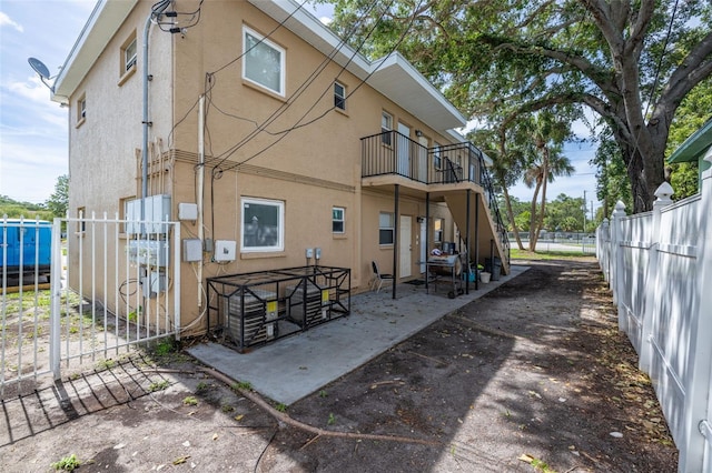 1799 Russell St S, Saint Petersburg, FL 33712 - rear view of property with stucco siding, a balcony, and a patio area