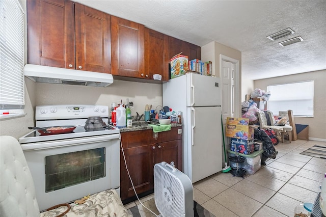 1799 Russell St S, Saint Petersburg, FL 33712 - kitchen featuring white appliances, under cabinet range hood, light tile patterned floors, and a textured ceiling