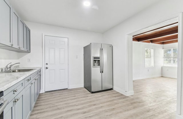 1807 E Bougainvillea Ave, Tampa, FL 33612 - kitchen with stainless steel fridge, light wood finished floors, beamed ceiling, and gray cabinetry