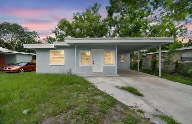 1807 E Bougainvillea Ave, Tampa, FL 33612 - view of front of home with driveway, an attached carport, and stucco siding