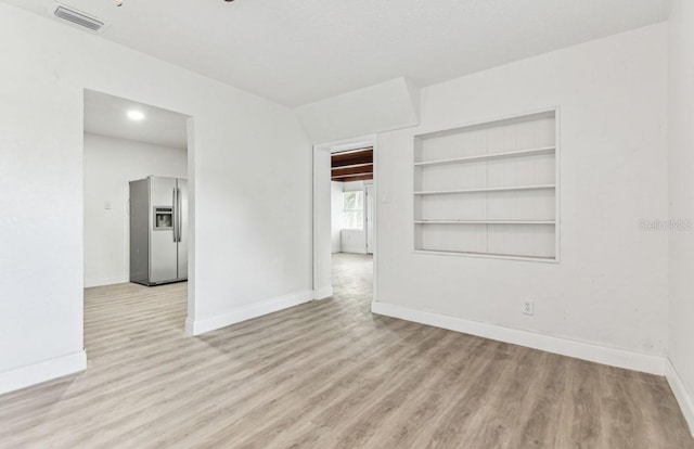 1807 E Bougainvillea Ave, Tampa, FL 33612 - empty room featuring light wood finished floors and built in shelves