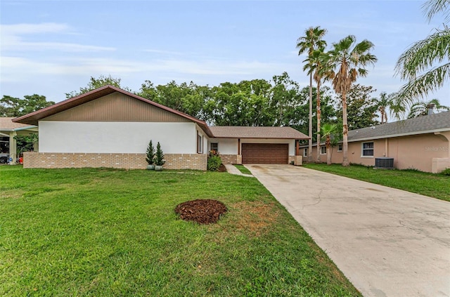 1558 Cottonwood Ter, Dunedin, FL 34698 - view of front of home with central AC, an attached garage, concrete driveway, a front yard, and stucco siding