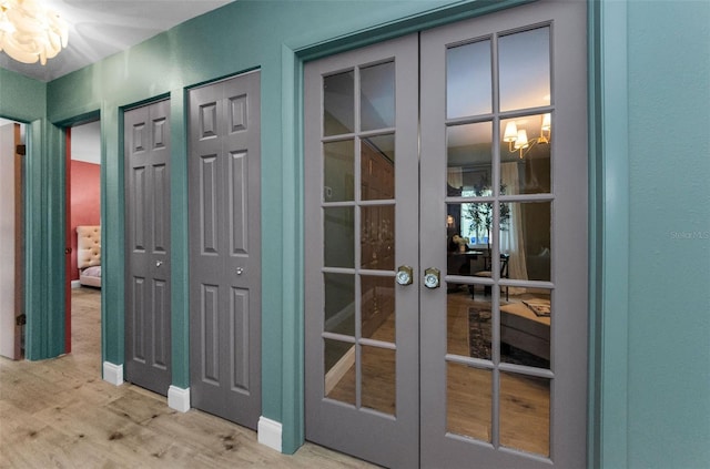 1558 Cottonwood Ter, Dunedin, FL 34698 - doorway to outside featuring french doors, wood finished floors, and a chandelier