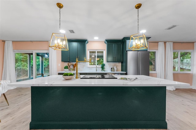 1558 Cottonwood Ter, Dunedin, FL 34698 - kitchen featuring freestanding refrigerator, a chandelier, green cabinets, plenty of natural light, and recessed lighting
