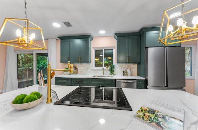 1558 Cottonwood Ter, Dunedin, FL 34698 - kitchen featuring a chandelier, green cabinets, appliances with stainless steel finishes, a sink, and tasteful backsplash