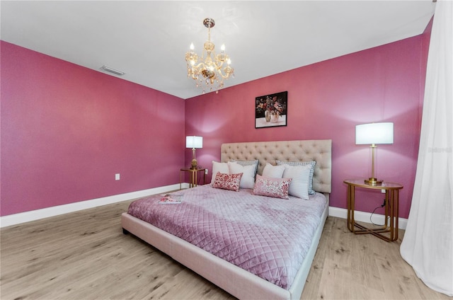 1558 Cottonwood Ter, Dunedin, FL 34698 - bedroom featuring wood finished floors, a chandelier, and baseboards