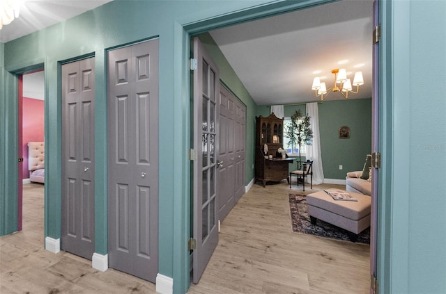 1558 Cottonwood Ter, Dunedin, FL 34698 - entryway featuring a chandelier, light wood finished floors, and baseboards