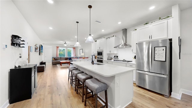 5645 Del Coronado Dr, Apollo Beach, FL 33572 - kitchen with stainless steel appliances, wall chimney range hood, a sink, open floor plan, and a kitchen breakfast bar