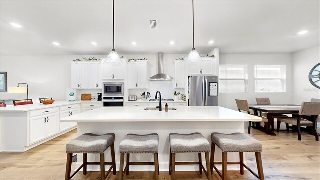 5645 Del Coronado Dr, Apollo Beach, FL 33572 - kitchen featuring appliances with stainless steel finishes, wall chimney exhaust hood, a breakfast bar area, a sink, and recessed lighting