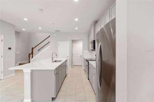 6711 Rocky Park St, Tampa, FL 33625 - kitchen with stainless steel appliances, gray cabinetry, a center island with sink, a sink, and recessed lighting